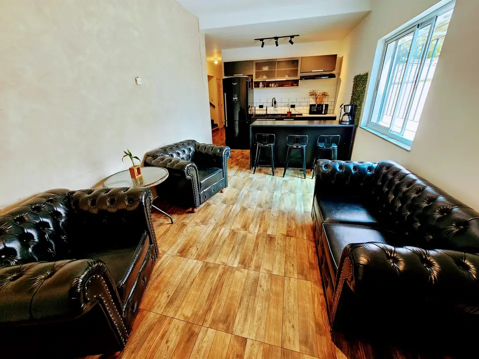Lounge com sofás Chesterfield e copa comum